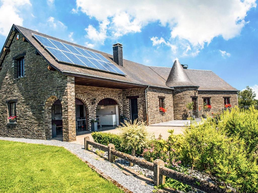 una casa de piedra con paneles solares en el techo en Appealing villa in Bi vre with garden, en Bièvre