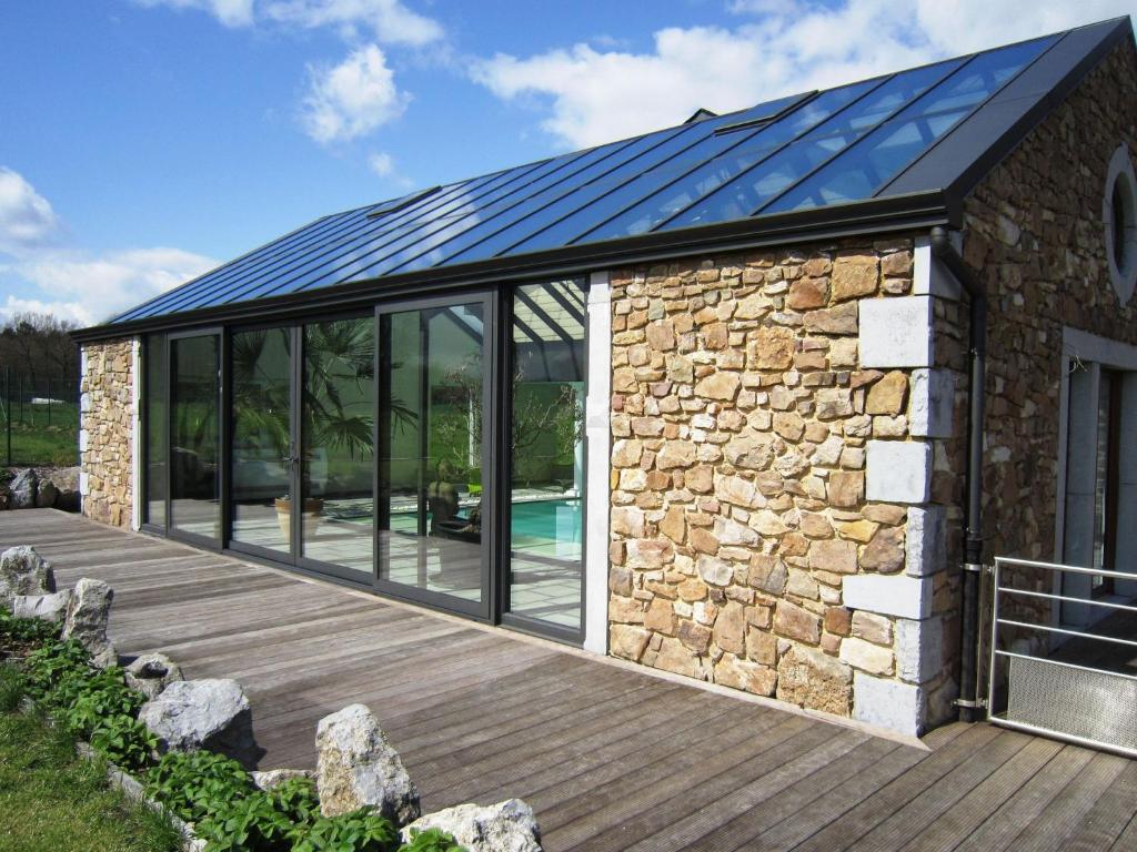 uma casa com um telhado solar num deque em Holiday home in Theux with indoor swimming pool and wellness em Theux