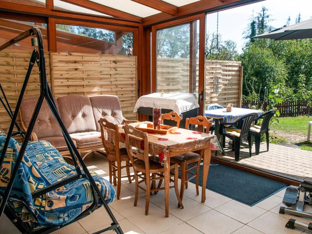 eine abgeschirmte Veranda mit einem Tisch und Stühlen in der Unterkunft Holiday home Houyet in Houyet