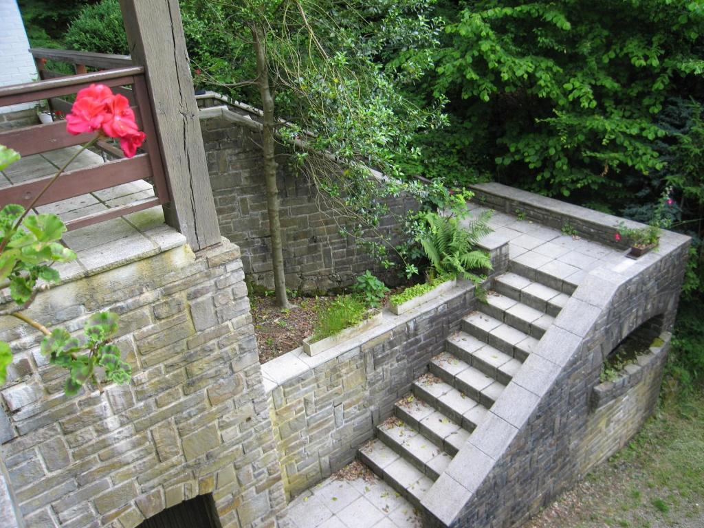 a brick retaining wall with stairs and a red flower at Amazing Chalet in Stavelot with Garden in Stavelot