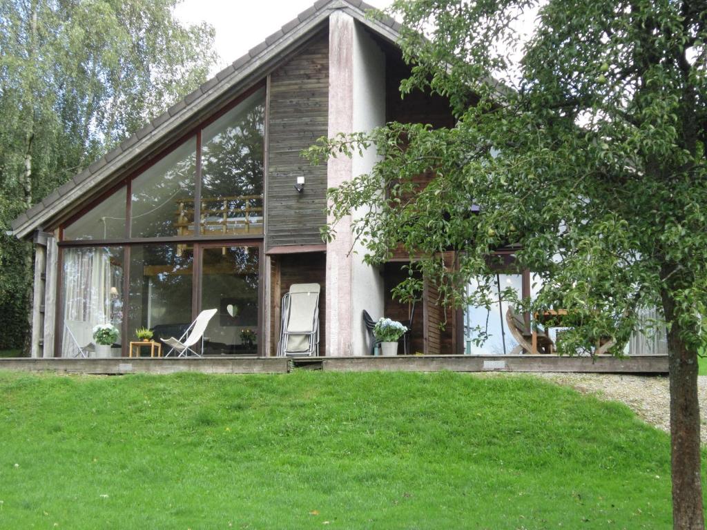 マルメディにあるContemporary Chalet in Malmedy near Forestのガラス窓と芝生のある家