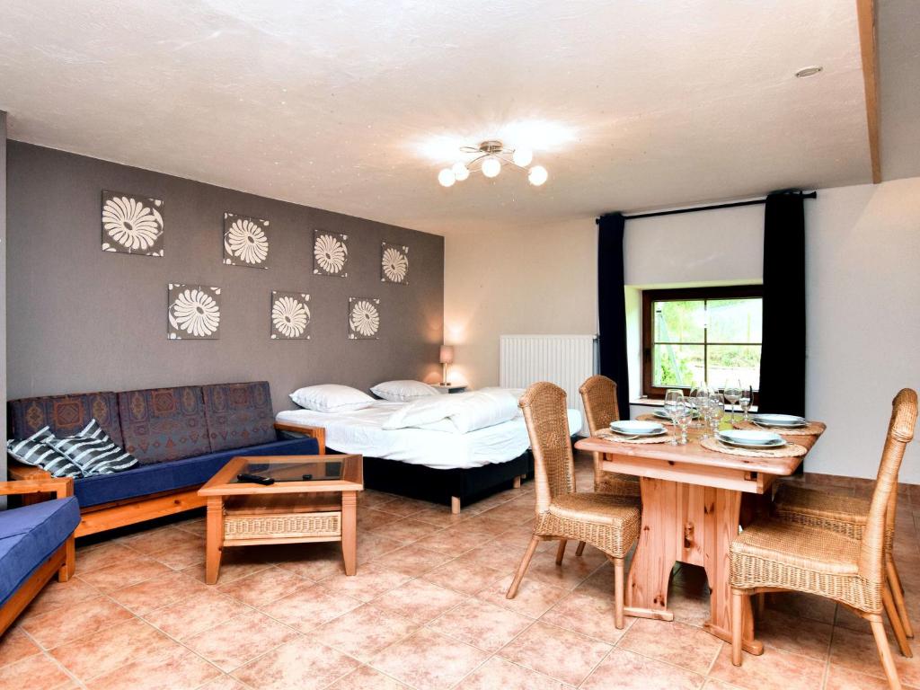 uma sala de estar com uma cama, uma mesa e cadeiras em Charming holiday home in St Vith with terrace em Heuem