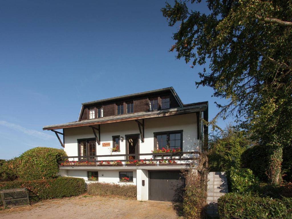 a white house with a balcony on top of it at Friendly and rustic family home with fireplace in Stavelot