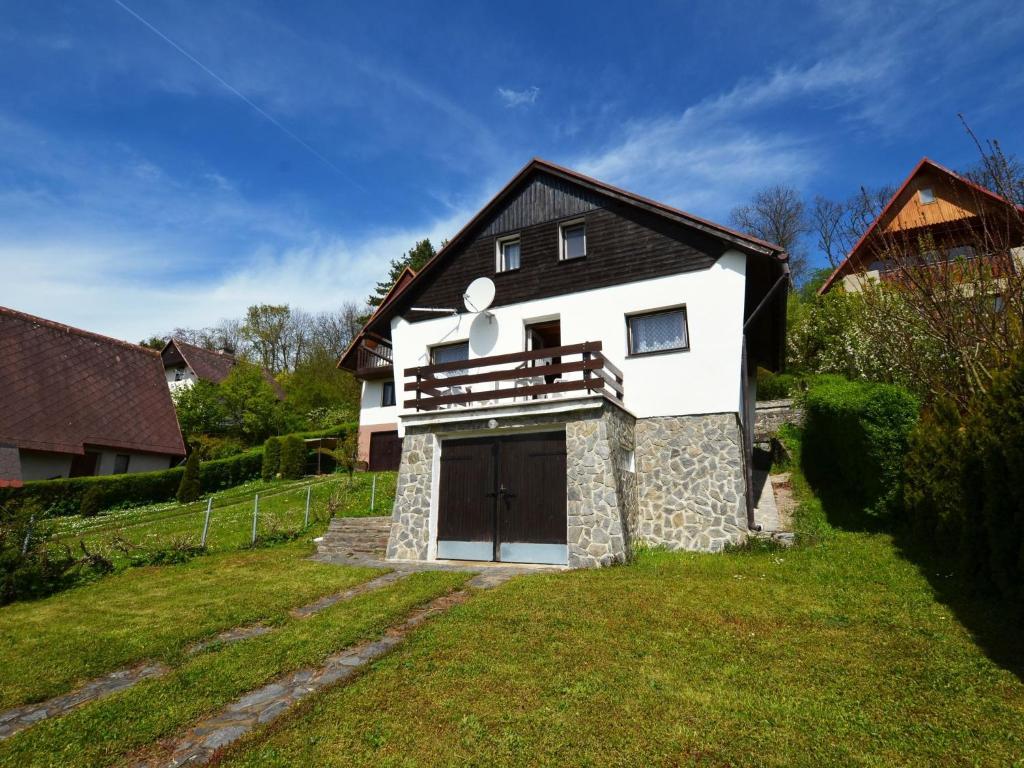 a white house with a garage in a yard at Detached cottage with fireplace, only 80 meters from the river Ohre in Radonice nad Ohří