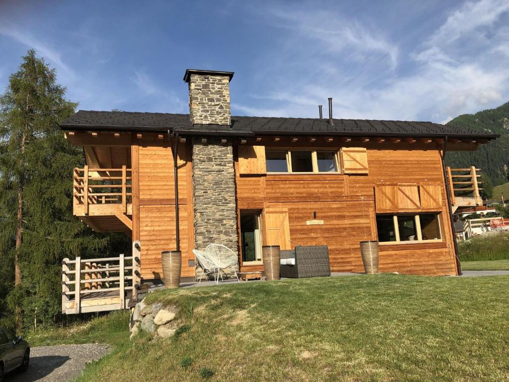 una casa de madera con porche y chimenea en Top chalet with unobstructed view inthe ski resort, en La Tzoumaz