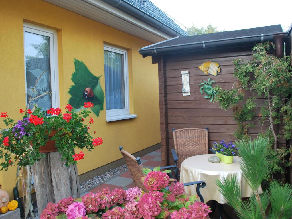 キュールングスボルンにあるLuxury apartment in Kuhlungsborn with huge terrace and gardenの花とテーブルのあるパティオ、