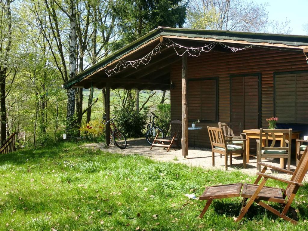 eine Hütte mit einem Tisch und Stühlen im Gras in der Unterkunft Dog friendly holiday home in the Kn ll in Neuenstein