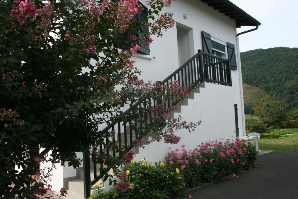 a white house with pink flowers on the stairs at Appartement Chez Pascaline in Saint-Jean-Pied-de-Port