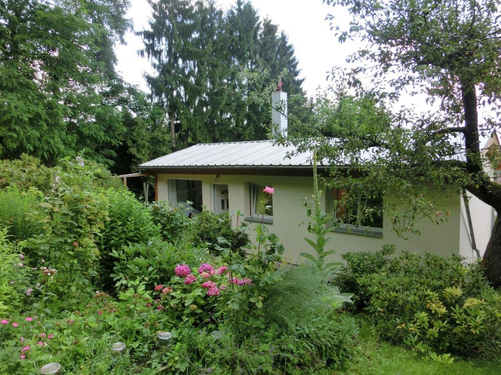 Holiday home in Wernigerode with private garden في فيرنيغيروده: منزل أبيض صغير في حديقة بها زهور