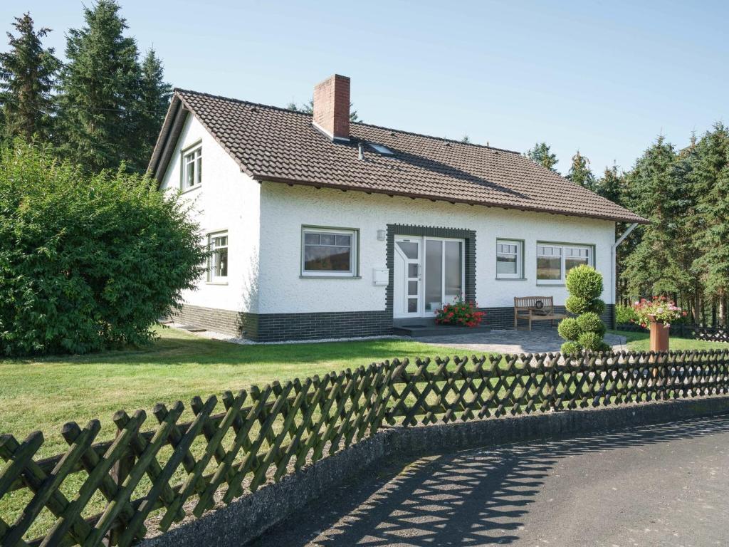 ein weißes Haus mit einem Zaun davor in der Unterkunft A detached holiday home in a highly scenic area in Trierscheid