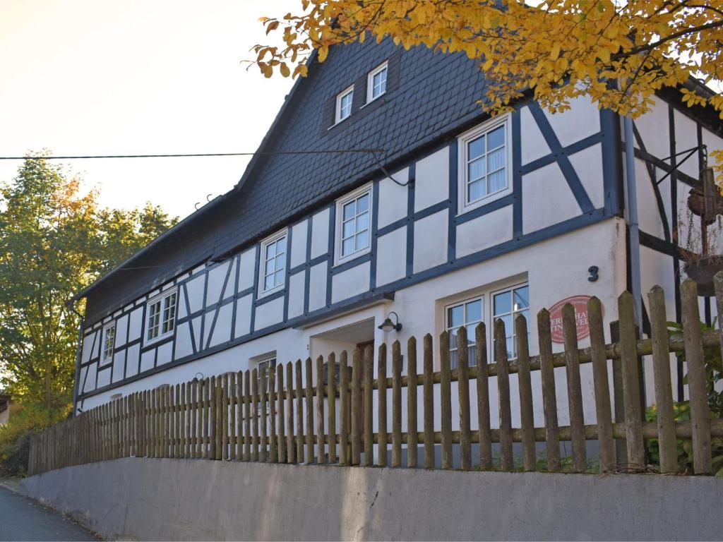 a blue and white house with a wooden fence at Holiday home in Sauerland with garden in Schmallenberg