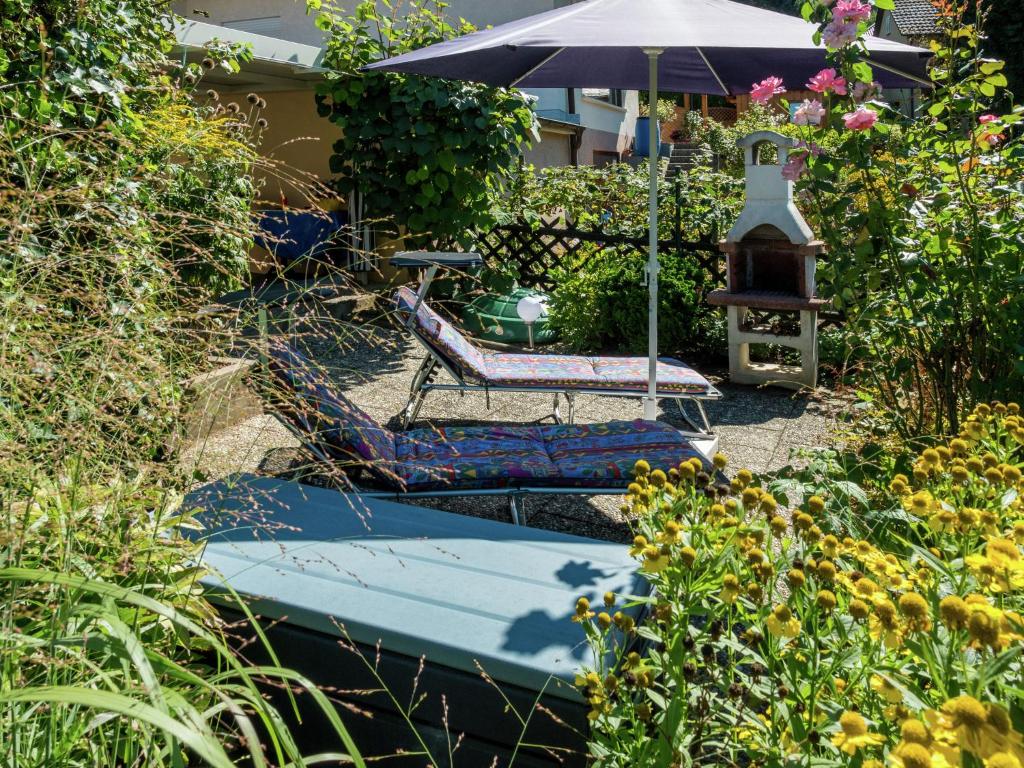 ハスラッハ・イム・キンツィクタールにあるCheerful apartment near city centre of Haslachのブランコと椅子、傘が備わる庭園
