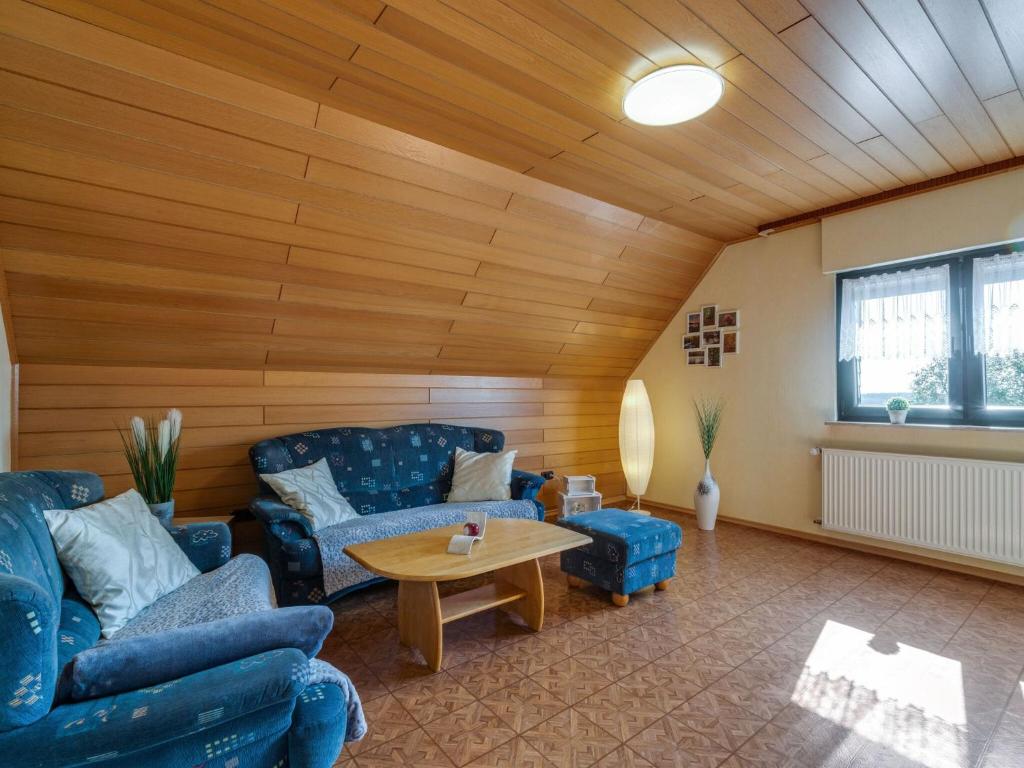 a living room with two blue couches and a table at Apartment in Westerwald with private balcony 