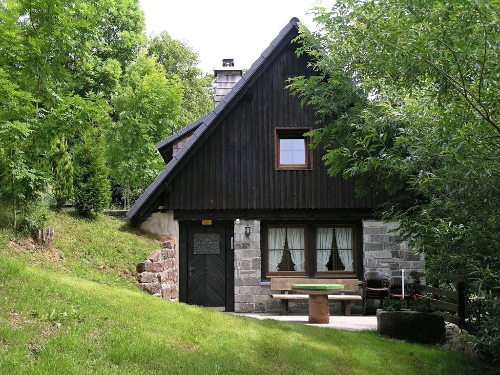 een klein huis met een bankje ervoor bij Converted old mill in St Georgen inBlack Forest in Sankt Georgen im Schwarzwald