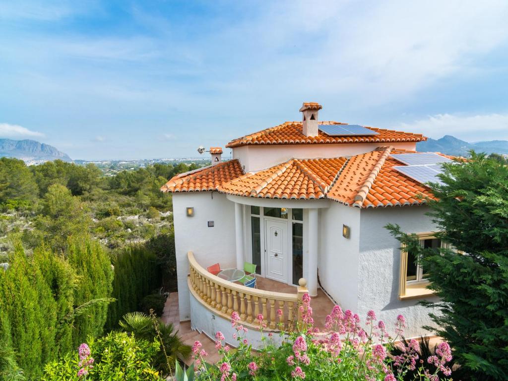 a small white house with an orange roof at Belvilla by OYO Casa Monta a de Alegria in Pedreguer