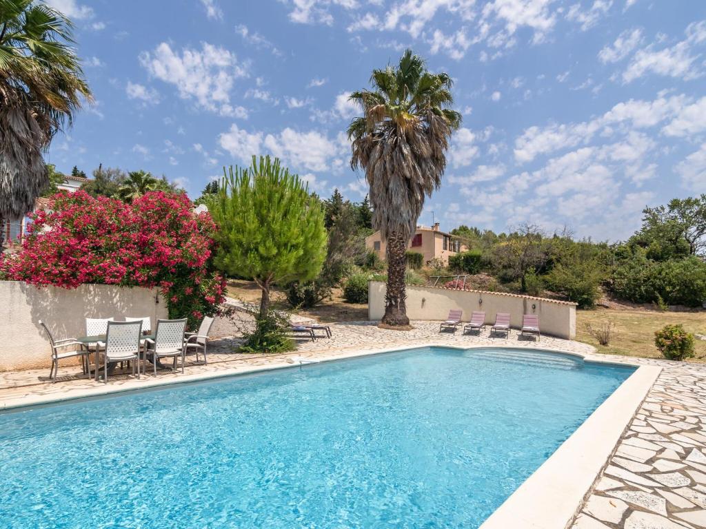 - une piscine bordée de chaises et de palmiers dans l'établissement Exquisite Villa in Beaufort with Swimming Pool, à Beaufort