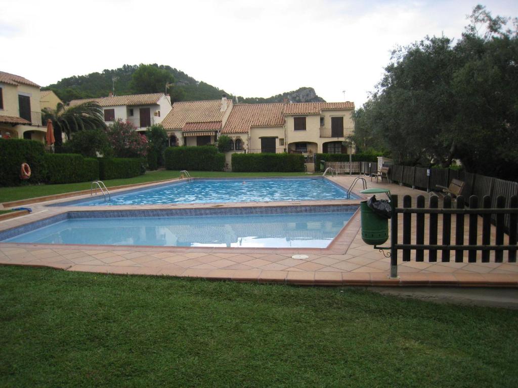 una piscina en un patio junto a una casa en Belvilla by OYO Les Oliveres 32, en L'Estartit