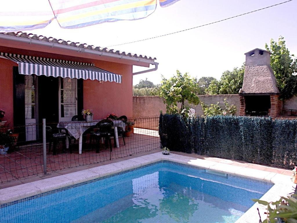 una piscina frente a una casa con mesa en Belvilla by OYO Casa Contento, en Sant Miquel de Fluvià