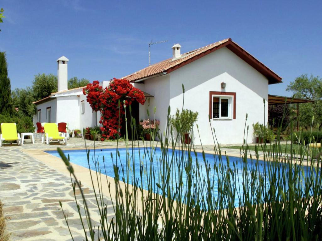 a villa with a pool in front of a house at Belvilla by OYO Casa Candela in Ronda