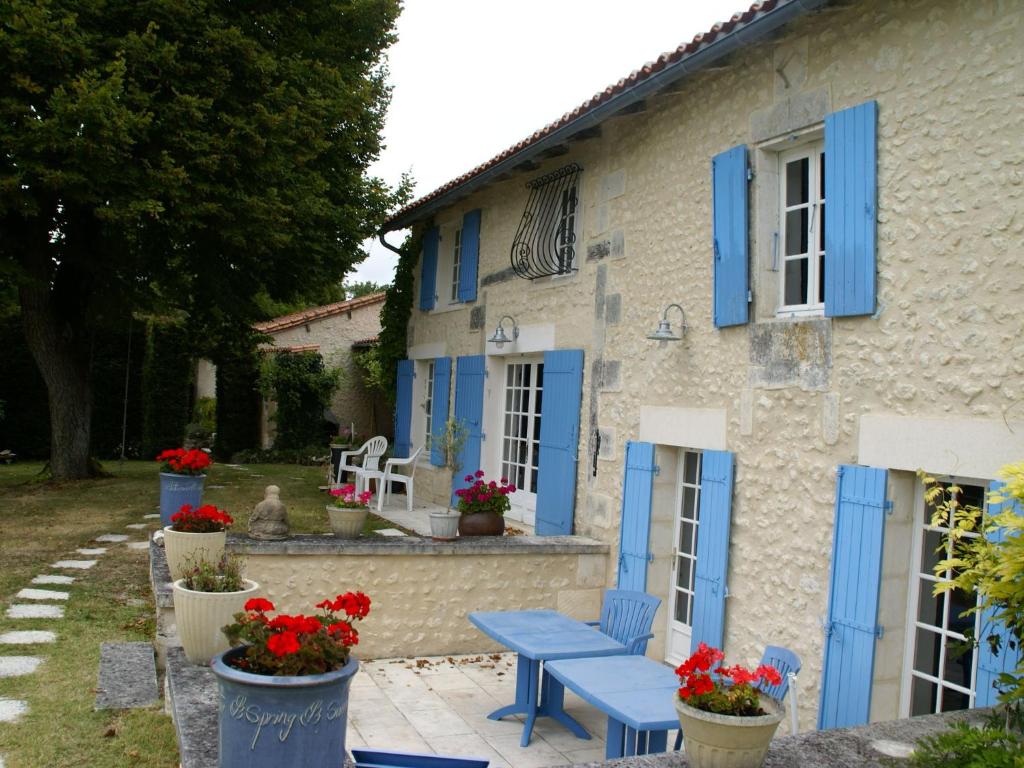uma casa com persianas azuis e uma mesa de piquenique azul em Beautiful holiday home with private pool em Lusignac