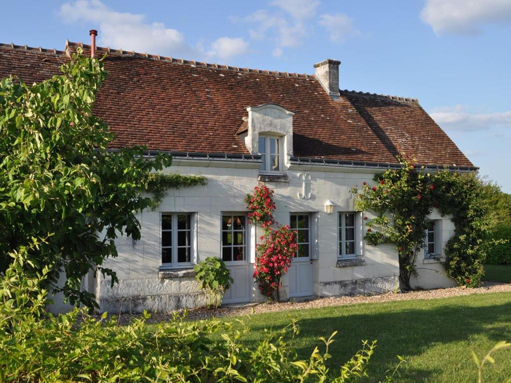 a white house with a red roof at Snug Holiday Home in Chambourg Sur Indre with Pool in Chambourg-sur-Indre