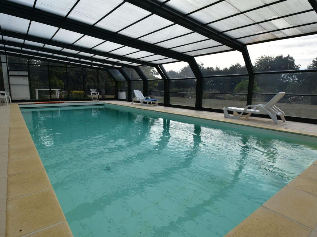 an indoor swimming pool with a retractable roof at Cosy holiday home with pool in Lamonzie-Montastruc