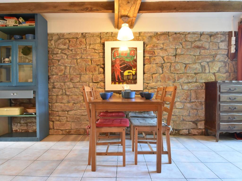 ein Esszimmer mit einem Holztisch und Stühlen in der Unterkunft Holiday Home in Saizy with Patio in Vignol