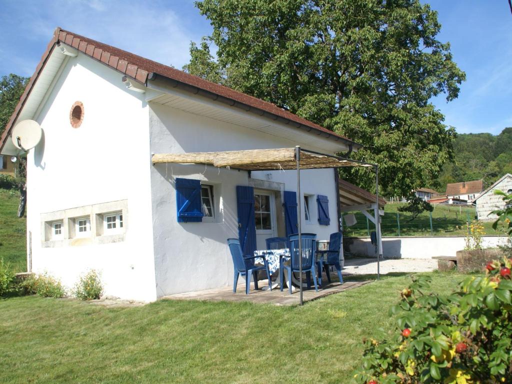 Casa blanca pequeña con mesa y sillas en Cosy holiday home with garden en Fresse-sur-Moselle