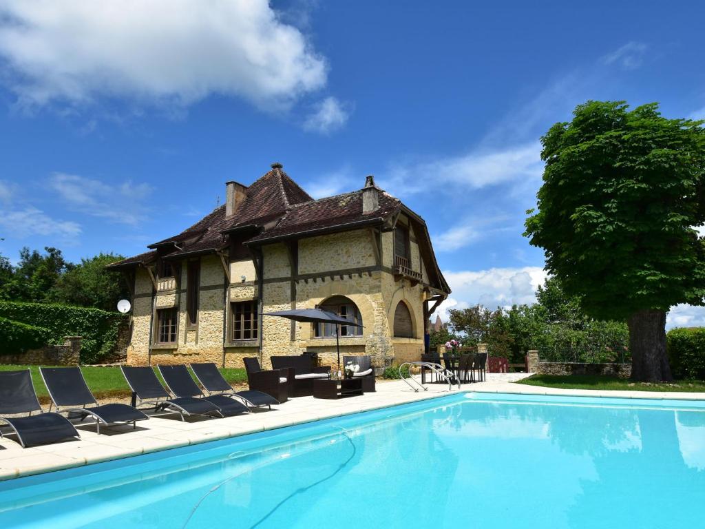 ベルベスにあるSumptuous Mansion in Belves with Poolの建物前のスイミングプール付き住宅