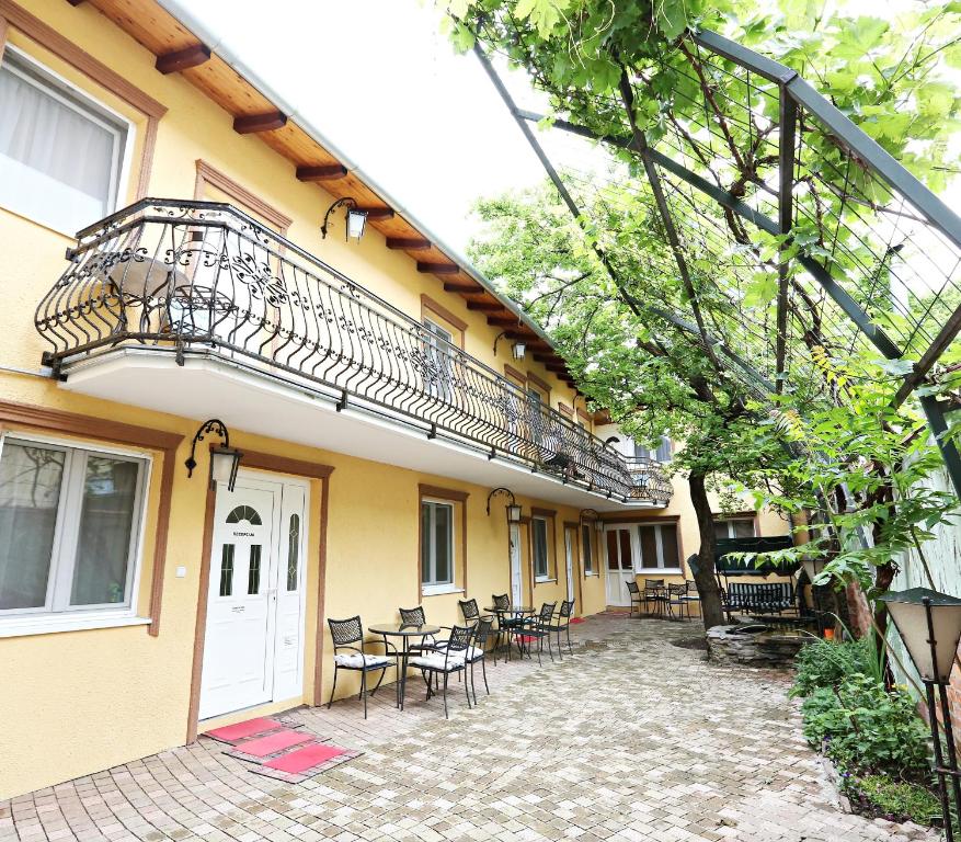 - un bâtiment avec un balcon, des tables et des chaises dans l'établissement Apartments & Rooms Vienna, à Osijek
