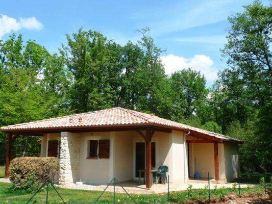 a small house with a thatched roof in a field at Comfortable villa with dishwasher, in the Dordogne in Gavaudun