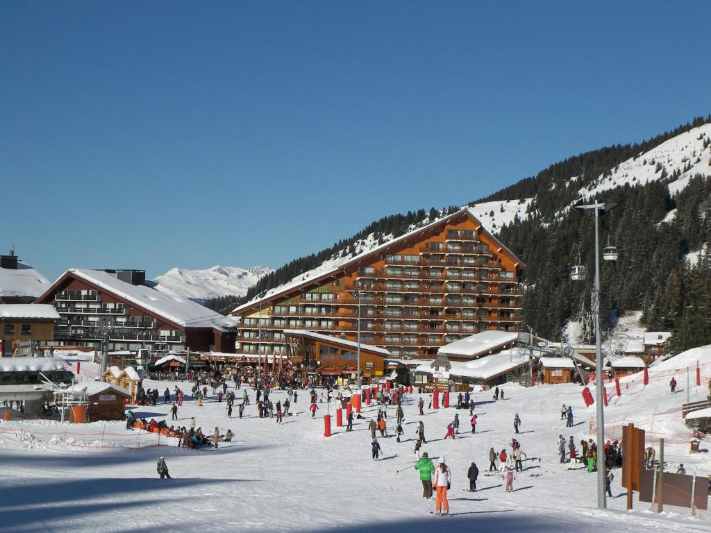 un groupe de personnes dans la neige devant un lodge de ski dans l'établissement Simplistic Apartment in M ribel near Les 3 Vall es, à Méribel