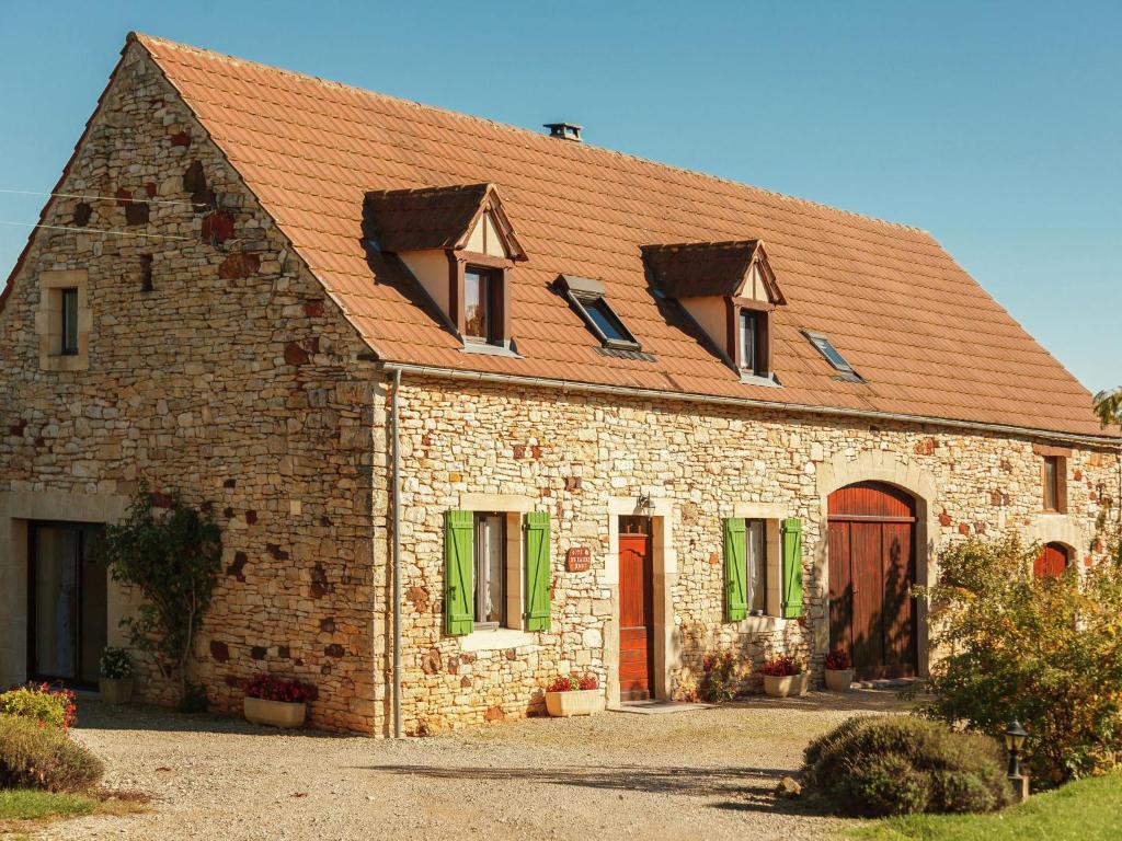 un grand bâtiment en briques avec un toit rouge dans l'établissement Cosy holiday home near the Causses du Quercy, à Lavercantière