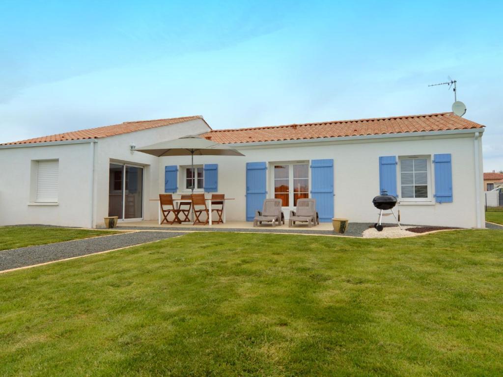 a house with a lawn in front of it at Modern holiday home with a garden near the beach in Saint-Hilaire-la-Forêt