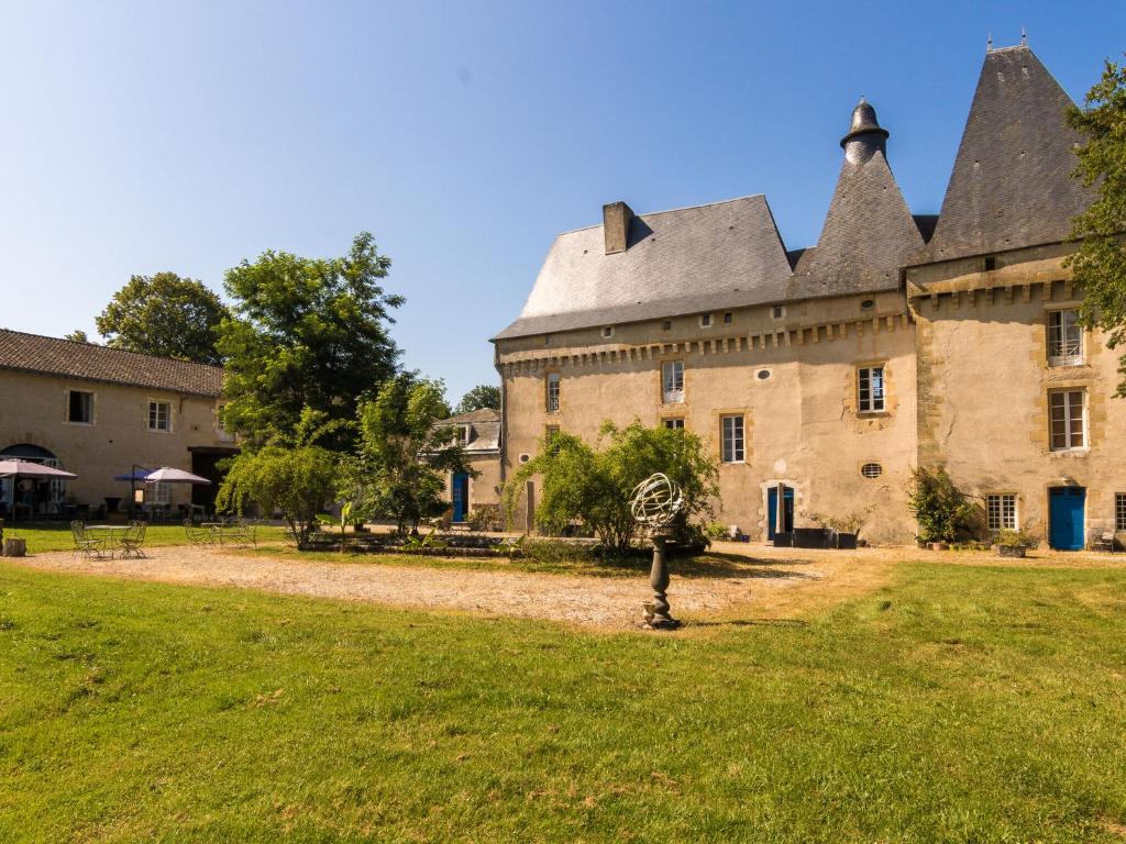 an old castle with a grass yard in front of it at Very spacious cottage with a separate guest house on a medieval domain in Chaleix