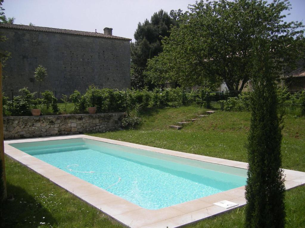 - une piscine dans une cour avec une pelouse dans l'établissement Spacious house with private pool, à Petit-Palais-et-Cornemps