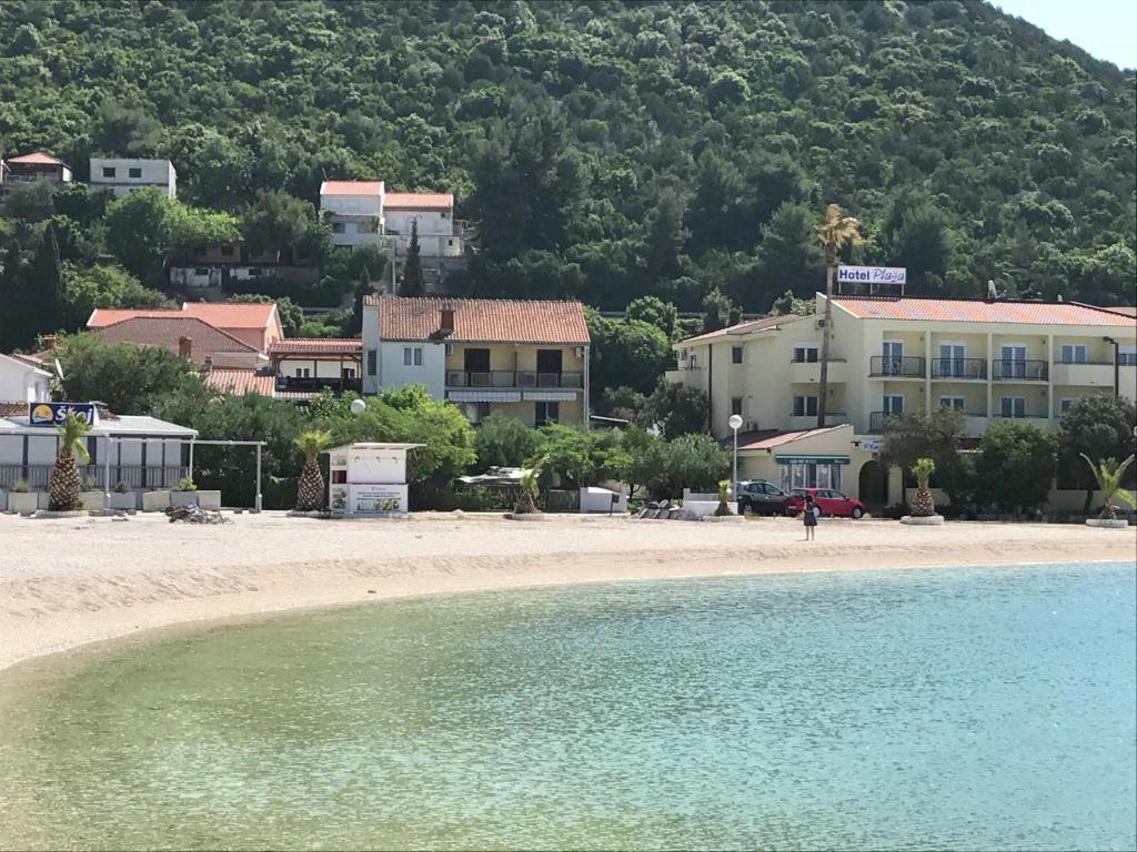 Spacious and modern apartment directly on the beach in Klek 70 km away from Dubrovnik في كليك: اطلالة على شاطئ به بيوت وماء