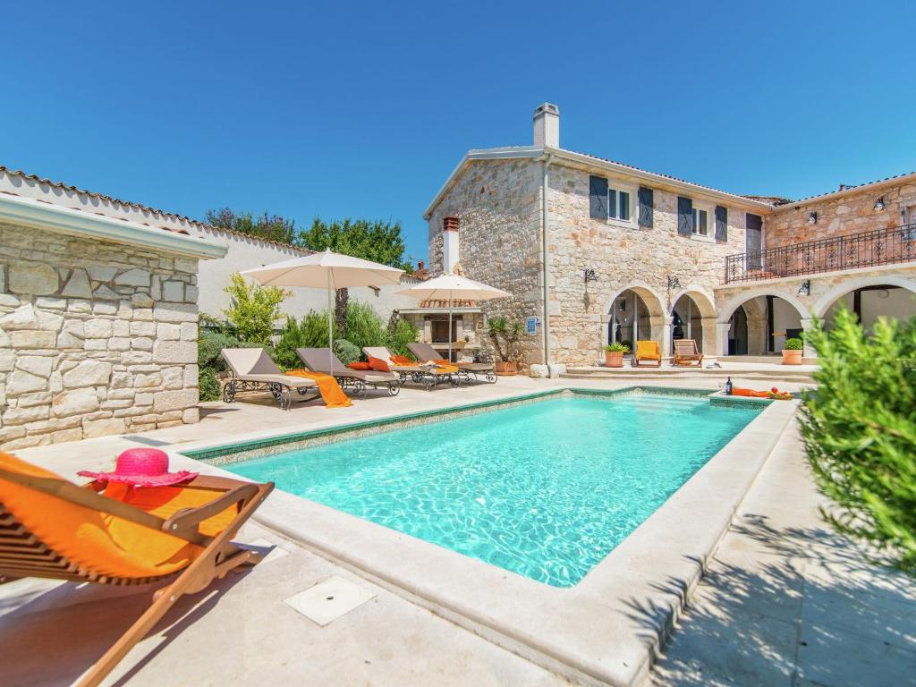 a villa with a swimming pool and a house at Rustic villa in Vrsar with private swimming pool in Marasi