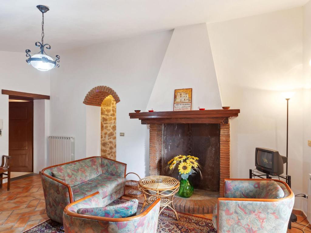 a living room with two chairs and a fireplace at Charmante Home with Garden in San Valentino