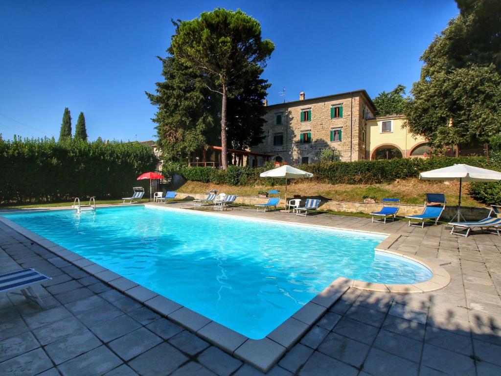 uma grande piscina com cadeiras e guarda-sóis em Belvilla by OYO Splendid Farmhouse with Jacuzzi em Gualdo Cattaneo