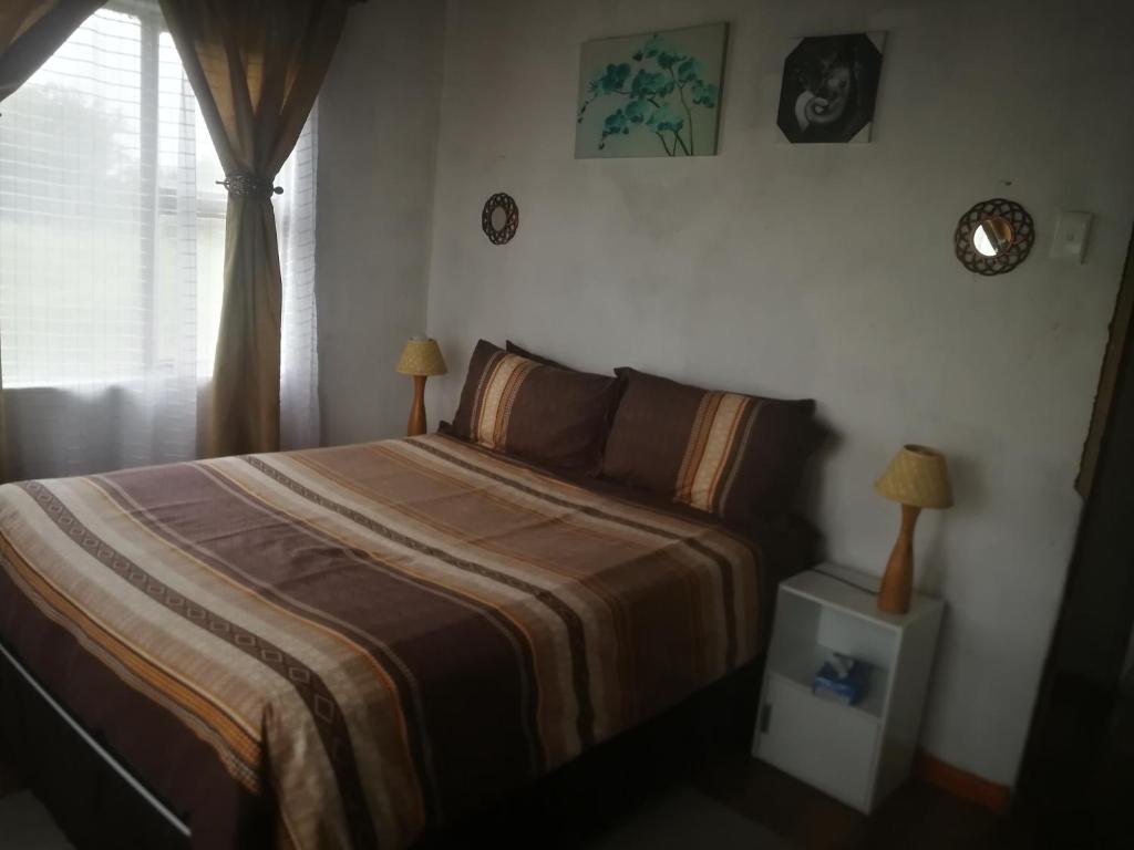 - une chambre avec un lit, deux lampes et une fenêtre dans l'établissement Port grosvenor Beach house, à Lusikisiki