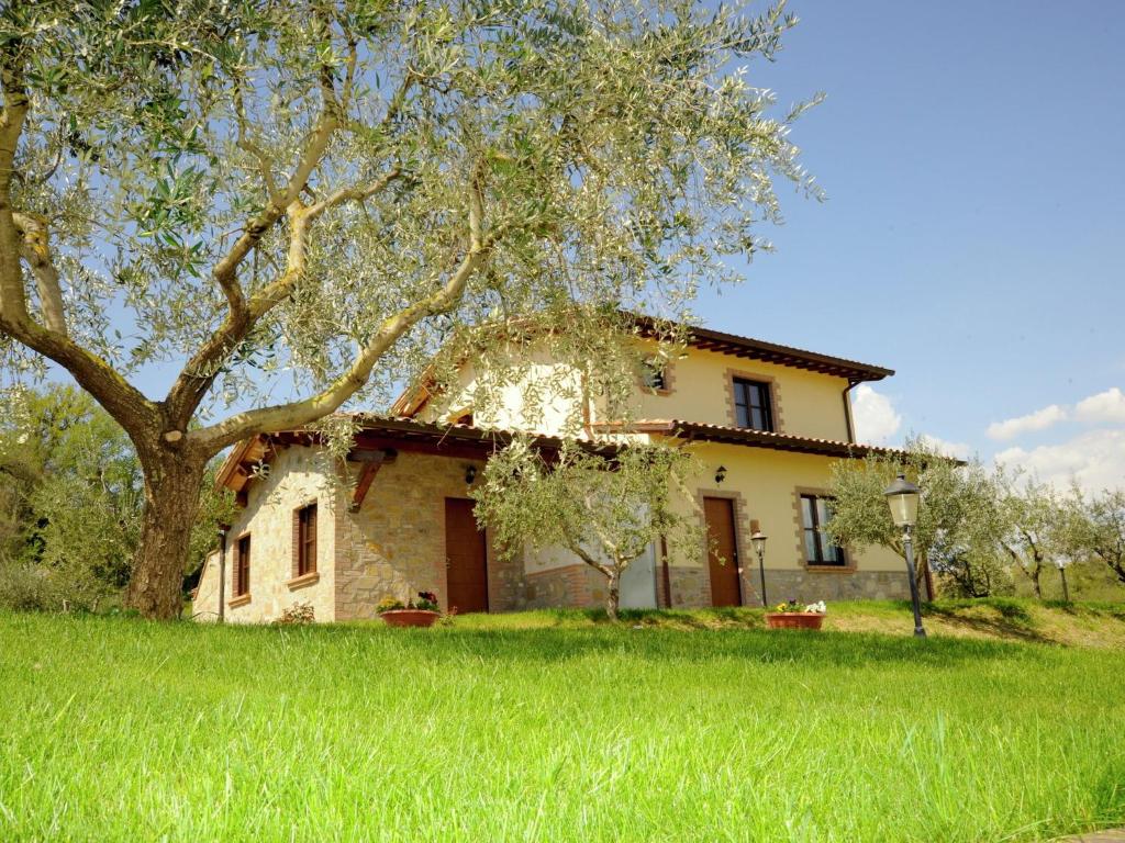 una casa con un albero di fronte di Belvilla by OYO Il Leccio a Perugia