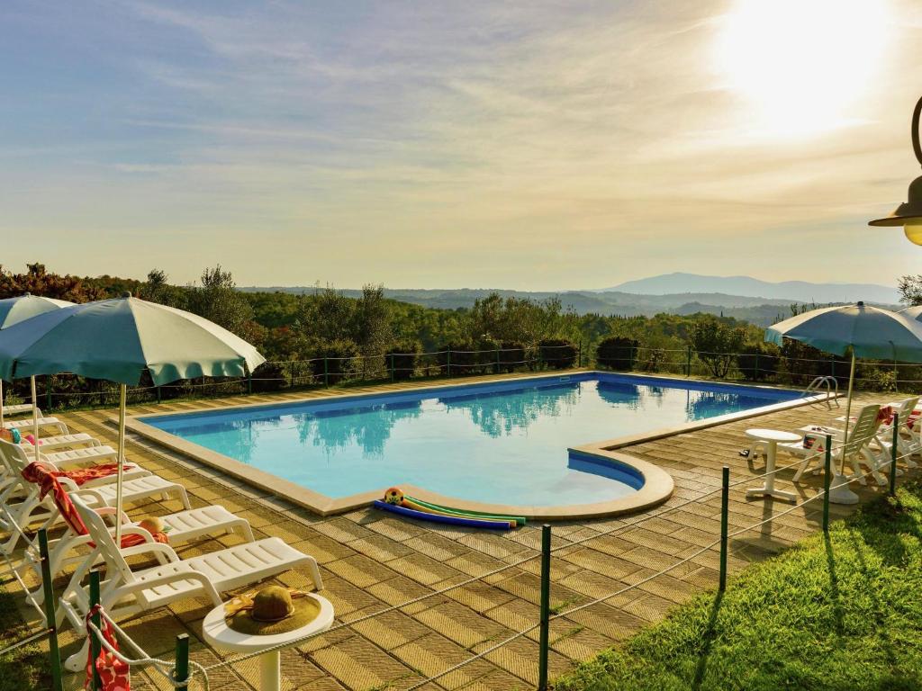 une grande piscine avec des chaises et des parasols dans l'établissement Farmhouse with air conditioning private terrace and pool, à Città della Pieve