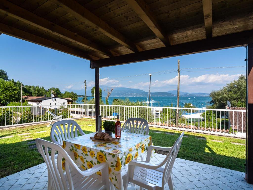 einen Tisch und Stühle auf einer Terrasse mit Aussicht in der Unterkunft Apartment on Lake Garda in Manerba with Pool in Montinelle