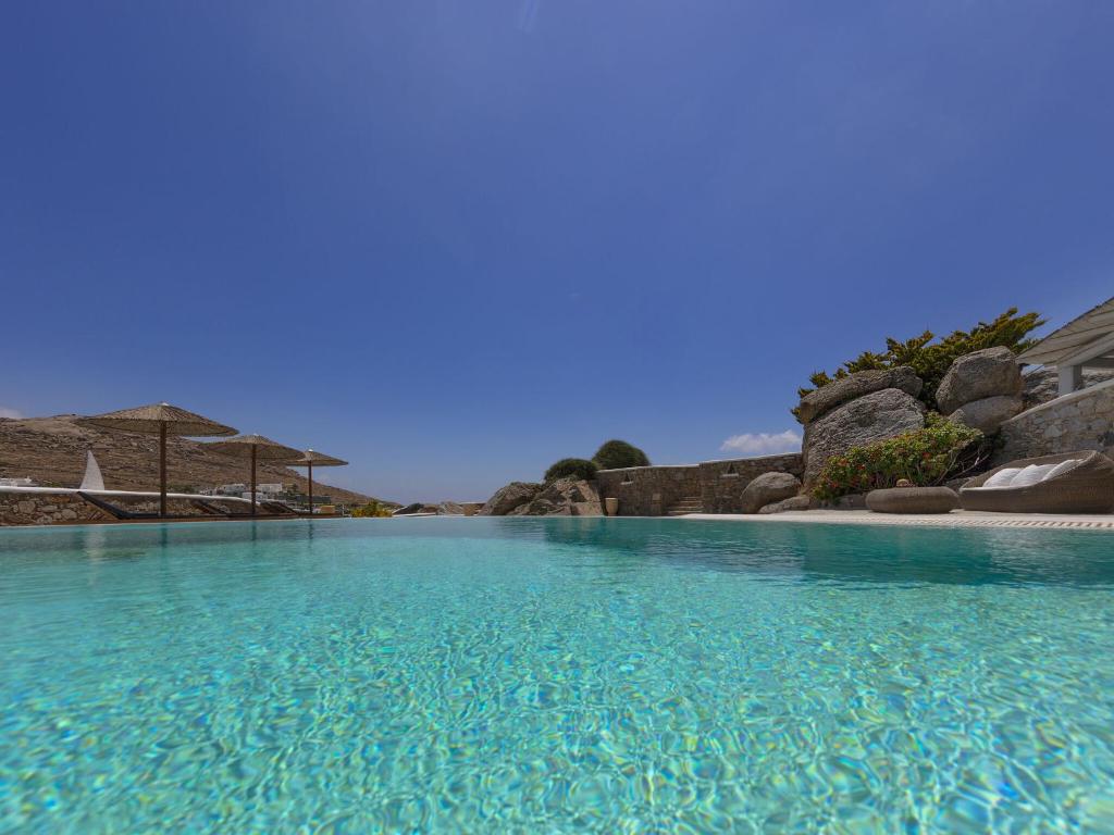 カラファティスにあるBeautiful large luxury villa in Mykonosの青空を背景にした大きな水のプール