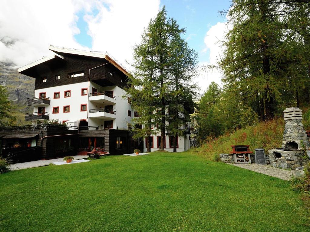 a large building with a grassy yard in front of it at Apartment in Aosta Valley near Ski Lift in Breuil-Cervinia