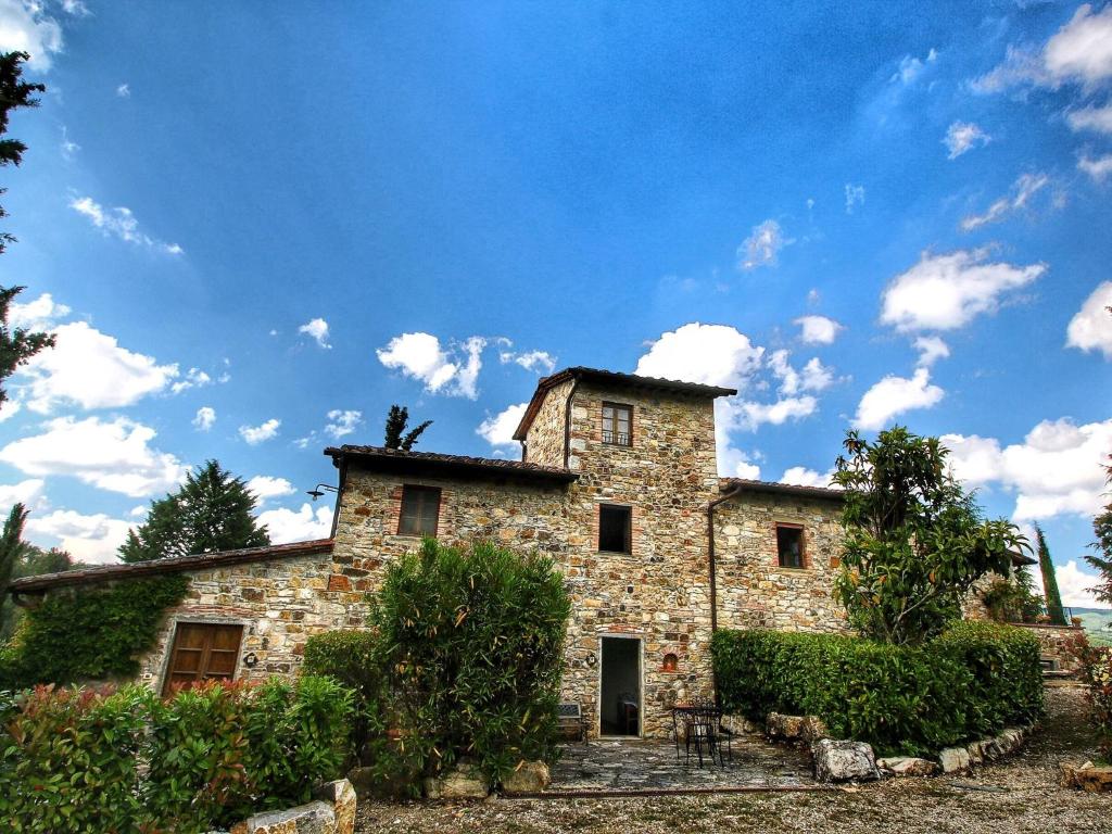 une ancienne maison en pierre avec un ciel bleu dans l'établissement Belvilla by OYO Uva, à Radda in Chianti
