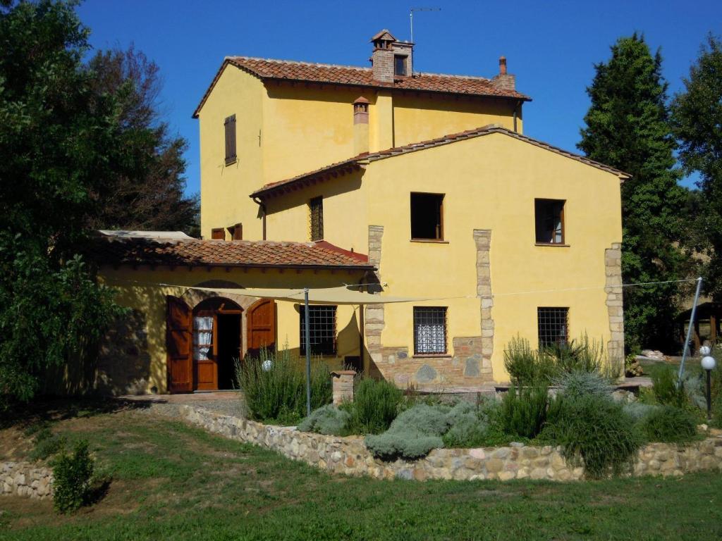 a large yellow house with a roof at Belvilla by OYO Mulinomanzi in Rosignano Marittimo