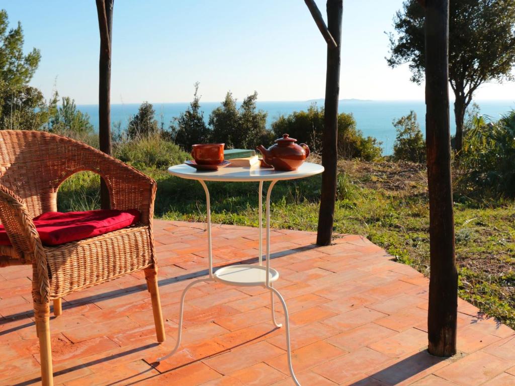 モンテ・アルジェンターリオにあるBelvilla by OYO Comfy Holiday Home with Gardenの海の景色を望むパティオ(テーブル、椅子付)