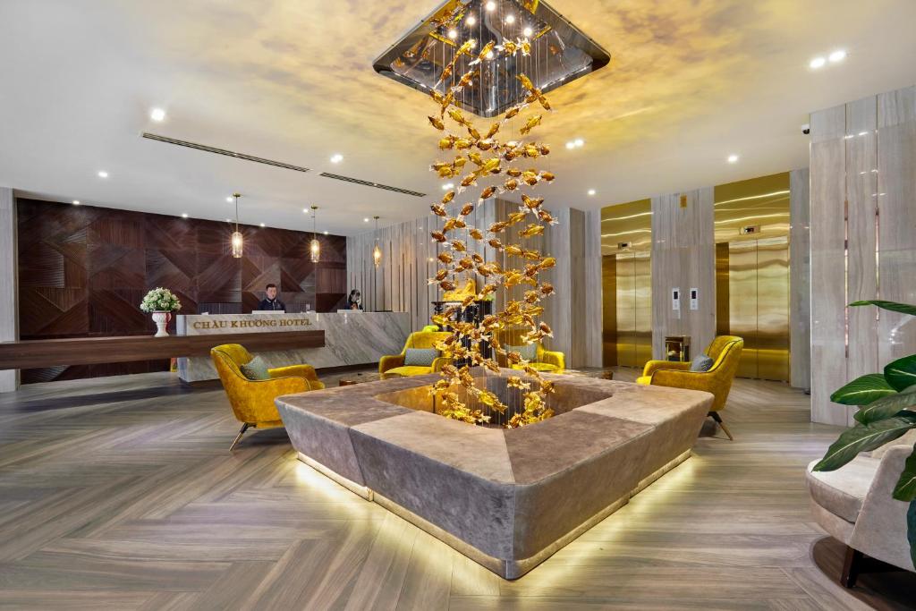 un vestíbulo con una mesa grande y sillas amarillas en CHAU KHUONG HOTEL en Long Xuyên